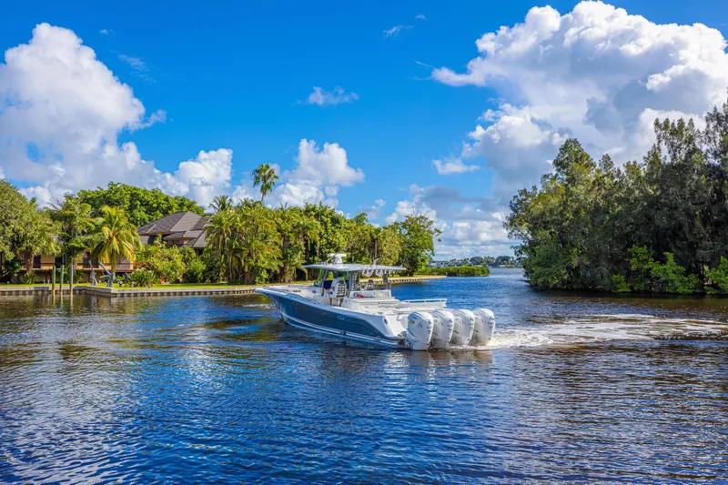 Slide: The Image of 2019 HCB 53 Sueños boat cruising on a scenic river under a bright blue sky. - 3