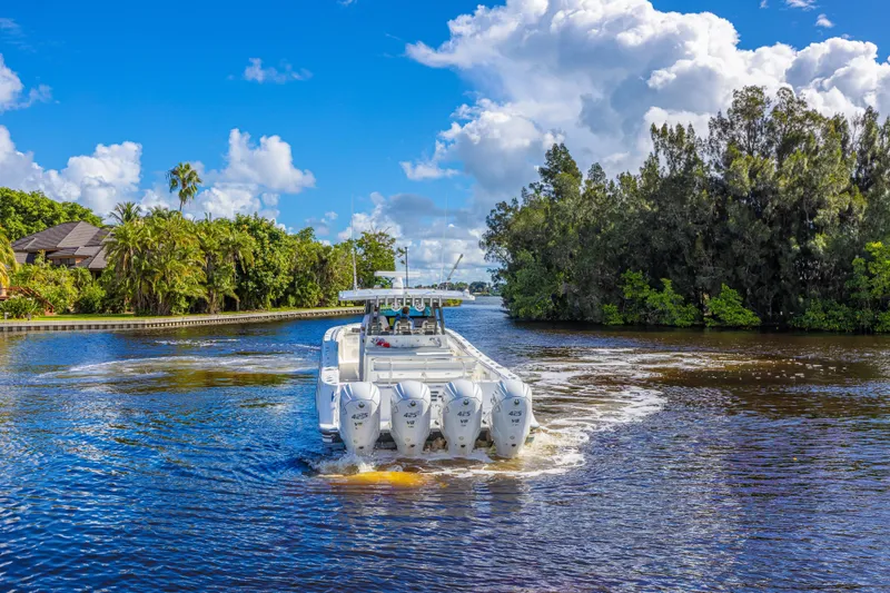 Slide: The Image of 2019 HCB 53 Sueños boat cruising on a scenic, tree-lined waterway under a blue sky. - 4