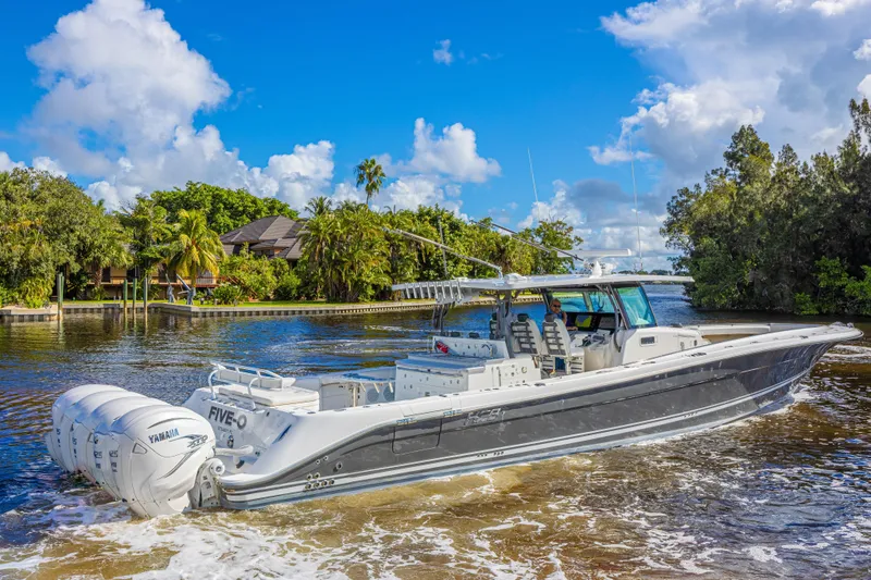 Slide: The Image of 2019 HCB 53 Sueños boat cruising on a scenic waterway with lush greenery. - 6