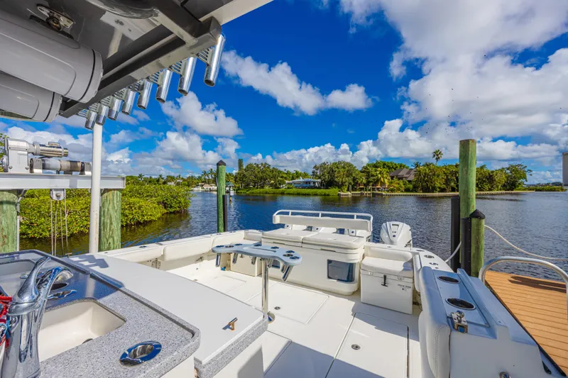 Slide: The Image of 2019 HCB 53 Sueños boat docked by scenic waterfront with lush greenery. - 9