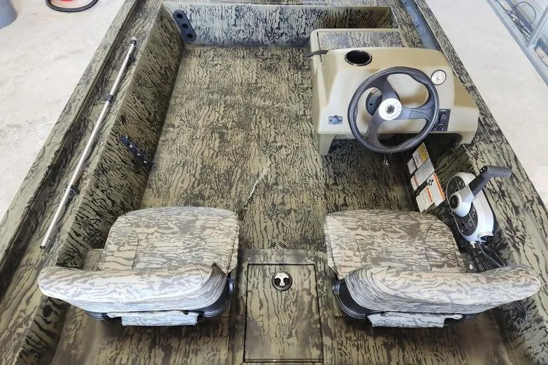 Slide: The Image of 2026 Tracker Grizzly 1754 SC boat interior with camouflage seats and steering console. - 7