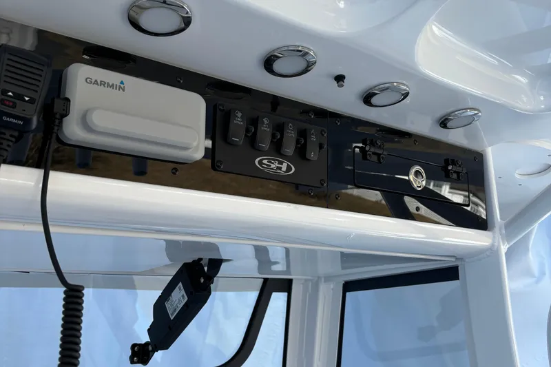 Slide: The Image of 2024 Sea Hunt Ultra 255 SE boat interior with tan seating and stainless steel fixtures. - 10
