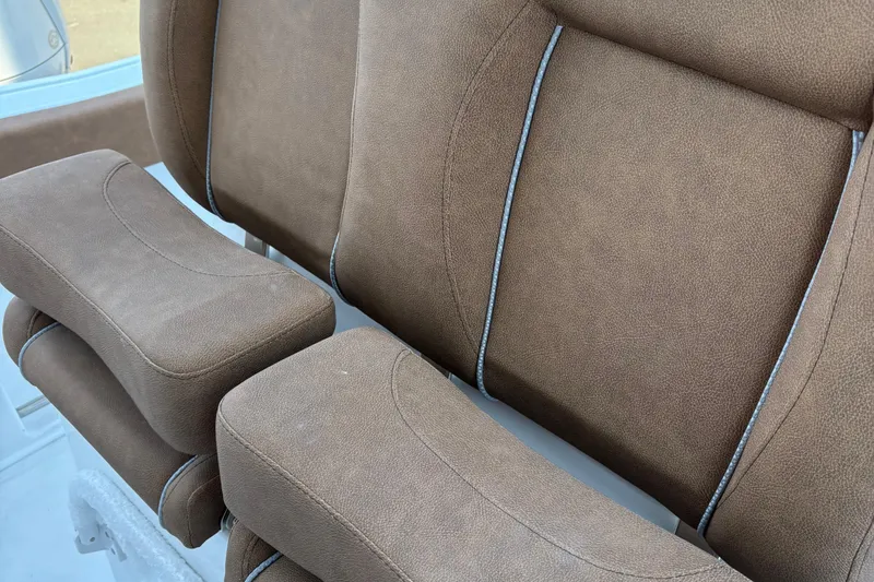 Slide: The Image of 2024 Sea Hunt Ultra 255 SE boat interior with tan seating and white railing. - 11