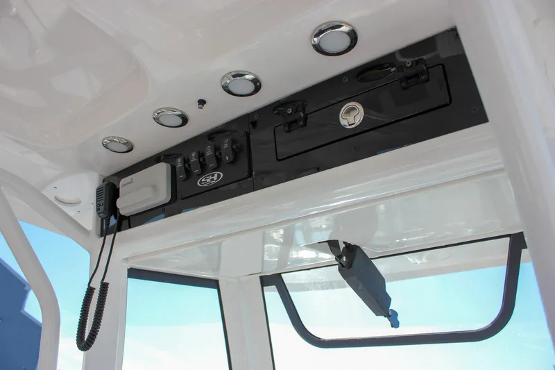 Slide: The Image of 2024 Sea Hunt Ultra 255 SE console with controls and storage compartment. - 20
