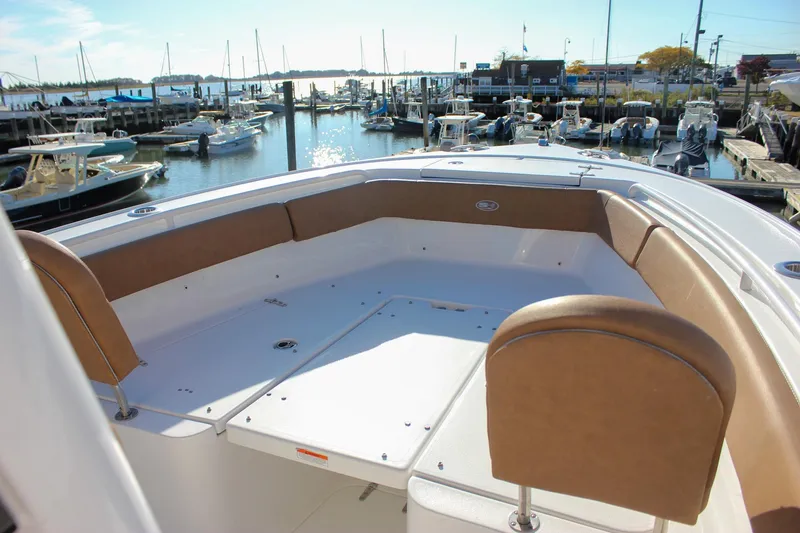 Slide: The Image of 2024 Sea Hunt Ultra 255 SE boat with spacious seating at marina. - 23