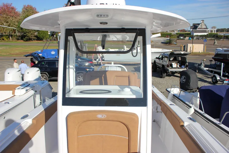 Slide: The Image of 2024 Sea Hunt Ultra 255 SE boat with tan seating and center console. - 25