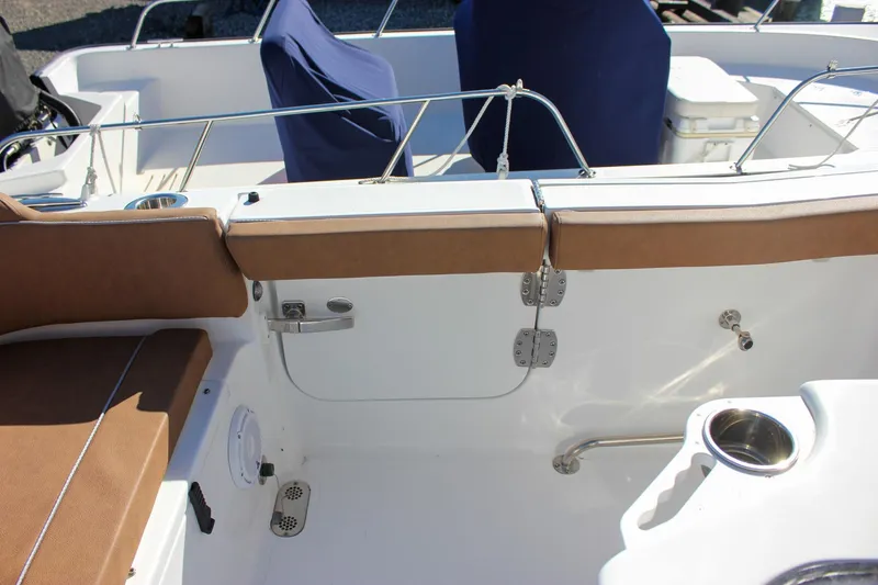 Slide: The Image of 2024 Sea Hunt Ultra 255 SE boat interior with brown seating and stainless steel fixtures. - 31