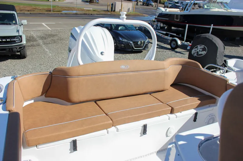 Slide: The Image of 2024 Sea Hunt Ultra 255 SE boat with tan seating, parked near vehicles and boats. - 32