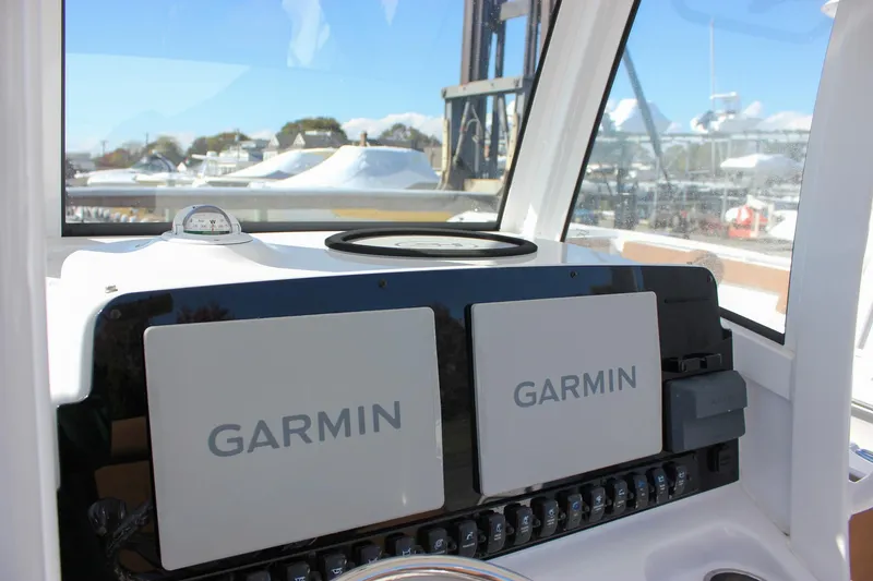 Slide: The Image of 2024 Sea Hunt Ultra 255 SE dashboard with dual Garmin displays and compass. - 36