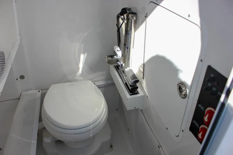 Slide: The Image of 2024 Sea Hunt Ultra 255 SE boat interior with toilet and storage compartment. - 39