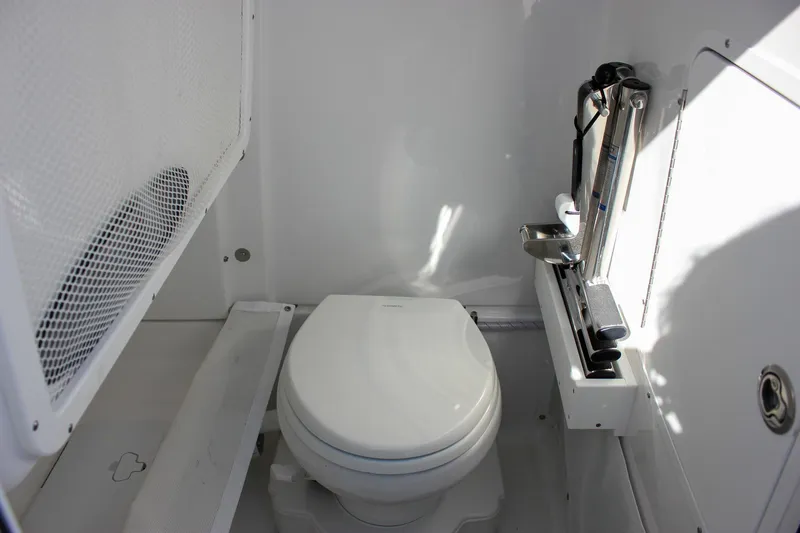 Slide: The Image of 2024 Sea Hunt Ultra 255 SE boat interior with compact marine toilet. - 40