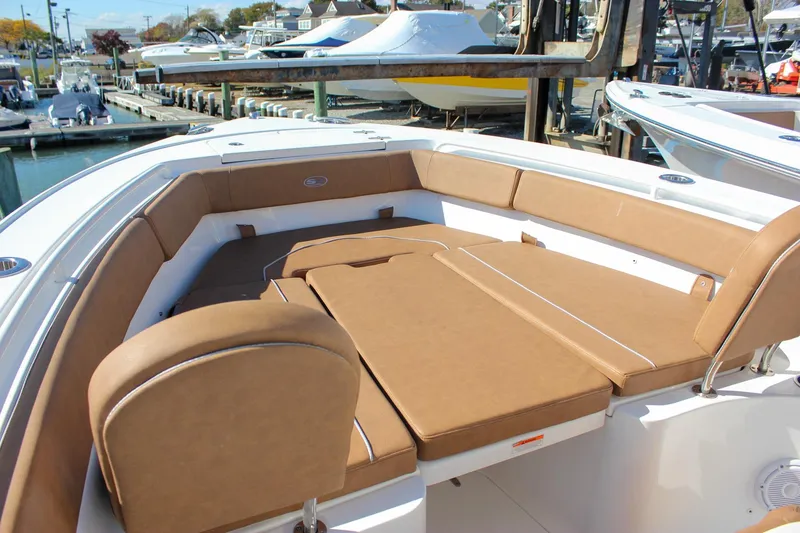 Slide: The Image of 2024 Sea Hunt Ultra 255 SE boat with spacious tan seating at a marina. - 41