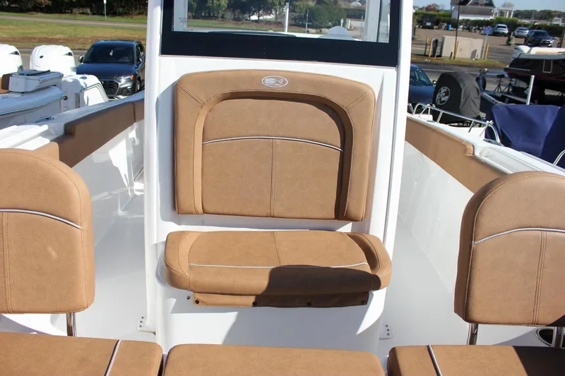 Slide: The Image of 2024 Sea Hunt Ultra 255 SE boat interior with tan cushioned seating. - 43