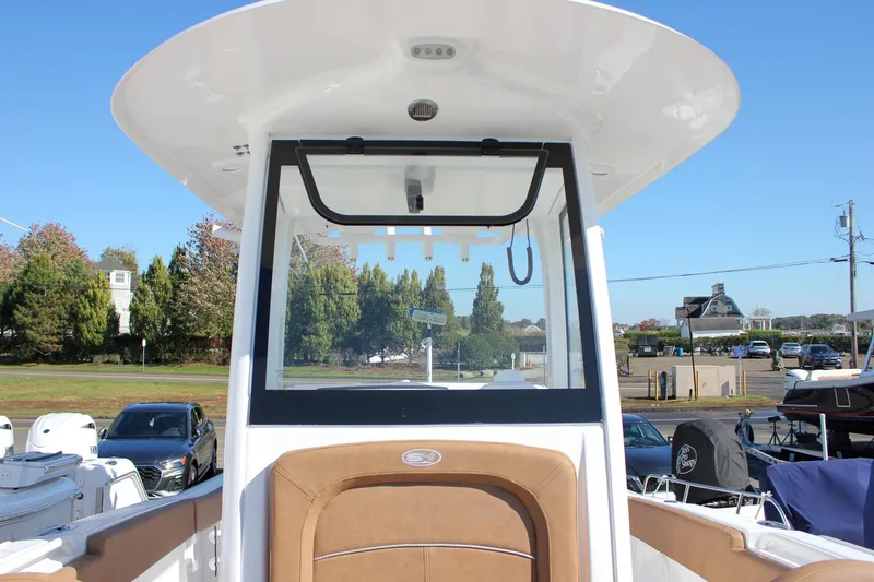 Slide: The Image of 2024 Sea Hunt Ultra 255 SE boat with brown seating and windshield, docked outdoors. - 44