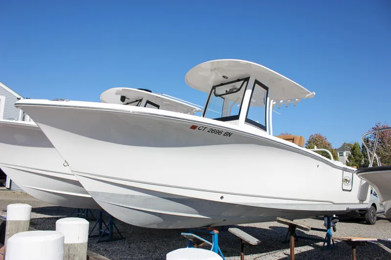 Slide: The Image of 2024 Sea Hunt Ultra 255 SE boat on display under clear blue sky. - 52
