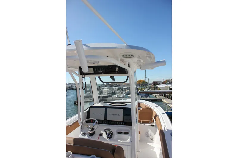 Slide: The Image of 2024 Sea Hunt Ultra 255 SE boat helm with Garmin displays, docked in marina. - 54