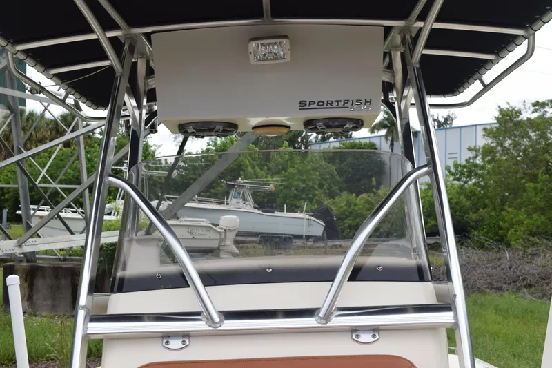 Slide: The Image of 2003 Scout 242 Sportfish boat interior with brown and beige seating, Suzuki engine visible. - 128