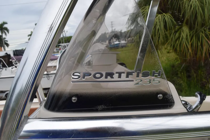 Slide: The Image of 2003 Scout 242 Sportfish boat with rod holders and canopy against cloudy sky. - 135