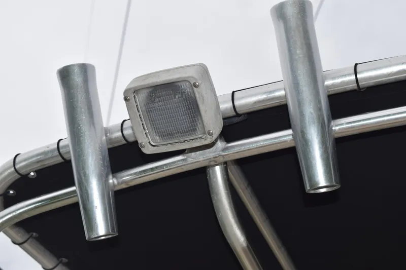 Slide: The Image of Close-up of a 2003 Scout 242 Sportfish boat's metal rod holders and light fixture. - 137