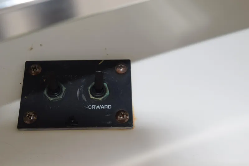 Slide: The Image of 2003 Scout 242 Sportfish boat dashboard with steering wheel and navigation controls. - 140