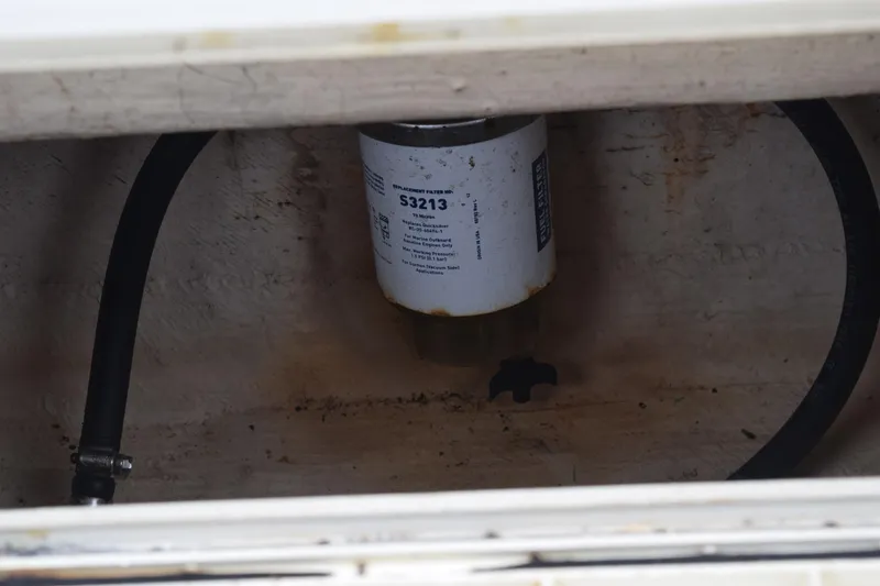 Slide: The Image of 2003 Scout 242 Sportfish boat with canopy, parked near trees and power lines. - 147