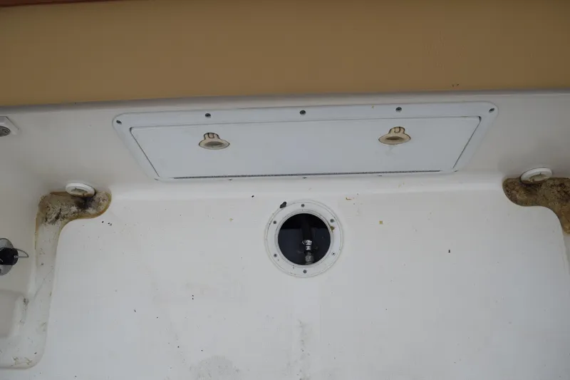 Slide: The Image of 2003 Scout 242 Sportfish boat with outboard motor, parked on grass. - 149