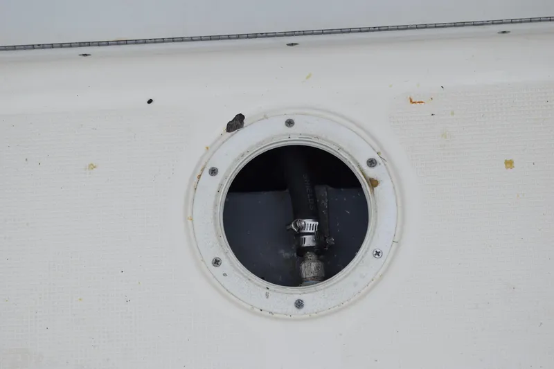 Slide: The Image of 2003 Scout 242 Sportfish boat with T-top, parked outdoors under cloudy sky. - 150