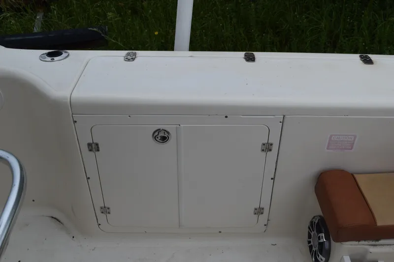 Slide: The Image of 2003 Scout 242 Sportfish boat with Suzuki outboard motor in grassy area. - 151