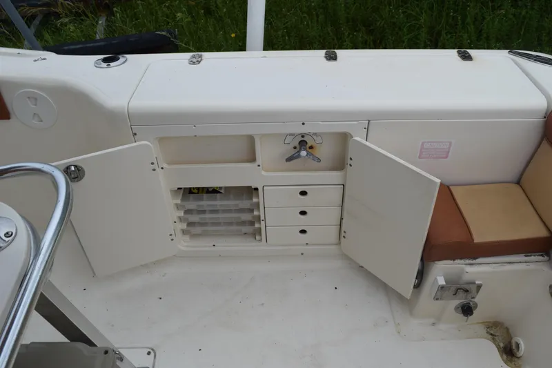 Slide: The Image of 2003 Scout 242 Sportfish boat interior with brown seating and control panel. - 152