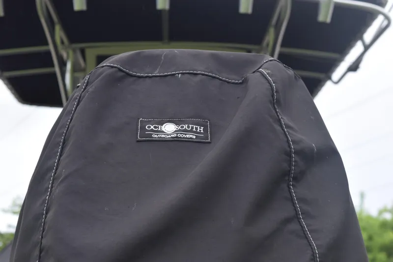 Slide: The Image of 2003 Scout 242 Sportfish boat interior with tan seating and nearby parked boats. - 24