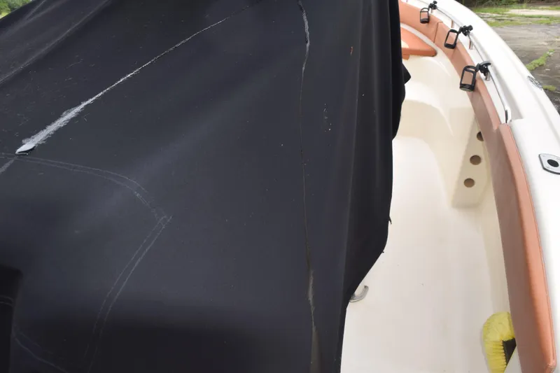 Slide: The Image of 2003 Scout 242 Sportfish boat with T-top and windshield, docked outdoors. - 55