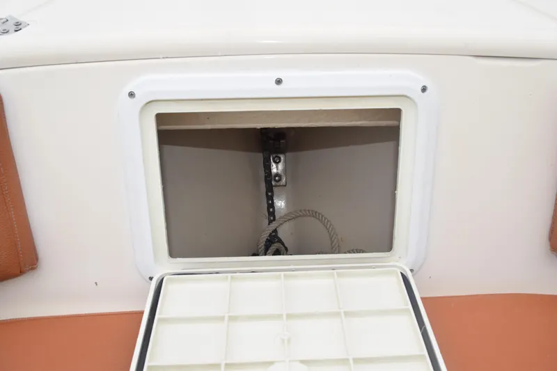 Slide: The Image of 2003 Scout 242 Sportfish boat storage compartment with open hatch and seating. - 67