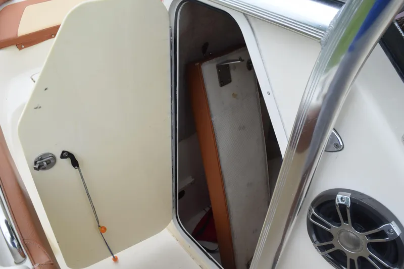 Slide: The Image of Close-up of a 2003 Scout 242 Sportfish boat's interior compartment with hose and fittings. - 83