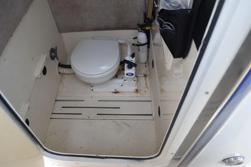 Slide: The Image of Open storage compartment on 2003 Scout 242 Sportfish boat with coiled hose inside. - 84