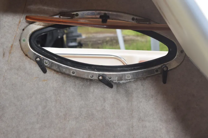 Slide: The Image of 2003 Scout 242 Sportfish boat interior with open storage compartment and cushioned seating. - 86