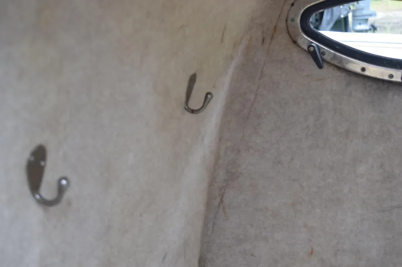 Slide: The Image of Open storage compartment on 2003 Scout 242 Sportfish boat with green hose inside. - 87