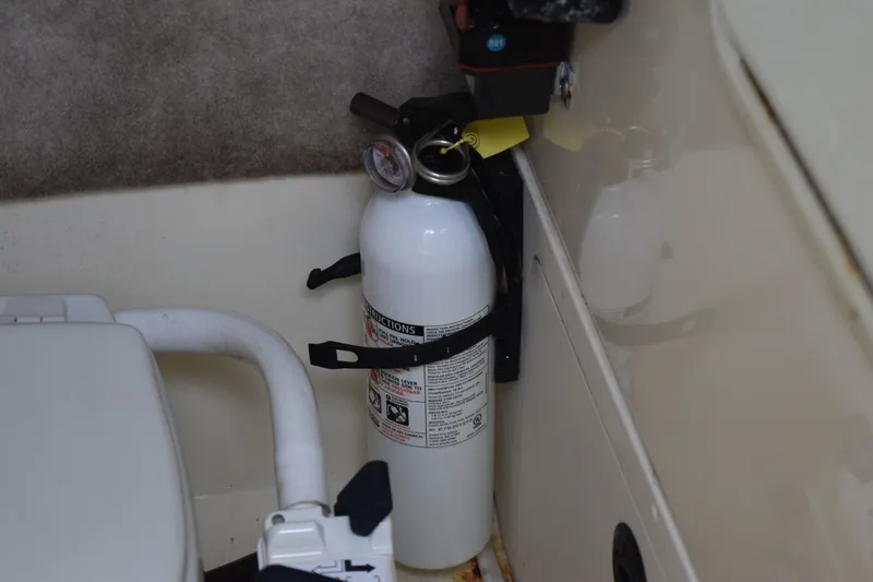 Slide: The Image of Storage compartment of 2003 Scout 242 Sportfish with coiled green hose and black ropes. - 88