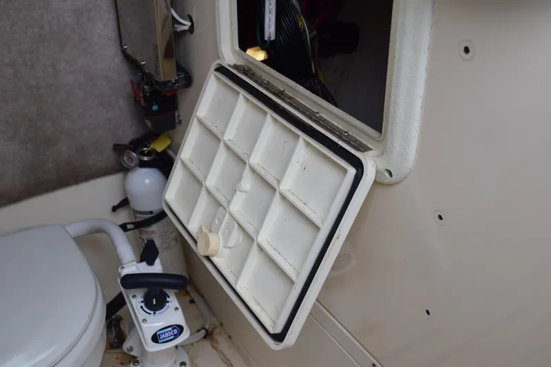 Slide: The Image of 2003 Scout 242 Sportfish boat console with open storage compartment and speakers. - 92