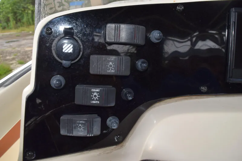 Slide: The Image of Control panel of a 2003 Scout 242 Sportfish boat with various switches. - 98