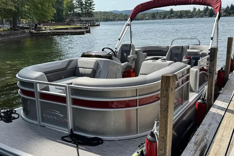 Slide: The Image of 2024 Bennington 22 SSRX boat interior with plush seating and cup holders by the water. - 10