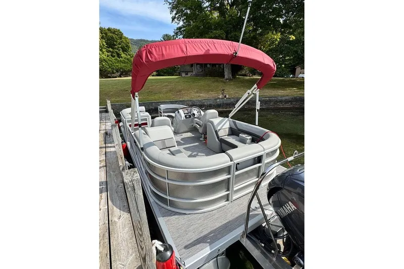 Slide: The Image of 2024 Bennington 22 SSRX pontoon boat with red seat covers on a calm lake. - 7