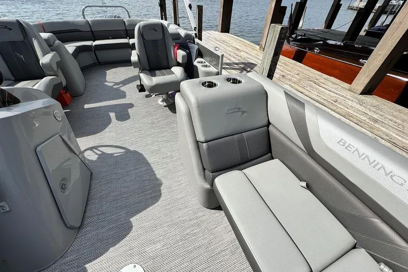 Slide: The Image of 2024 Bennington 22 SSRX pontoon boat docked on a serene lake. - 8