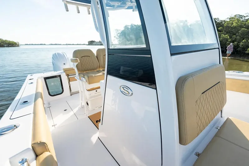 Slide: The Image of Manufacturer Provided Image: 2025 Sportsman Open 252 Center Console boat on calm water, featuring beige seating. - 10