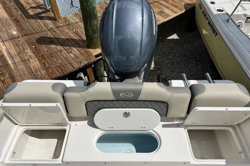 Slide: The Image of 2026 Key West 189 FS boat with outboard motor and seating, docked on wooden pier. - 12