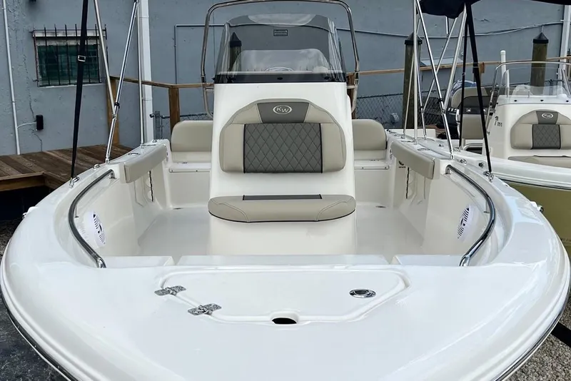 Slide: The Image of 2026 Key West 189 FS boat with cushioned seating and sleek design in a marina setting. - 4