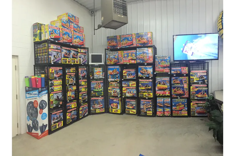 Slide: The Image of Display of colorful water sports equipment boxes in a store, featuring various inflatable towables. - 12