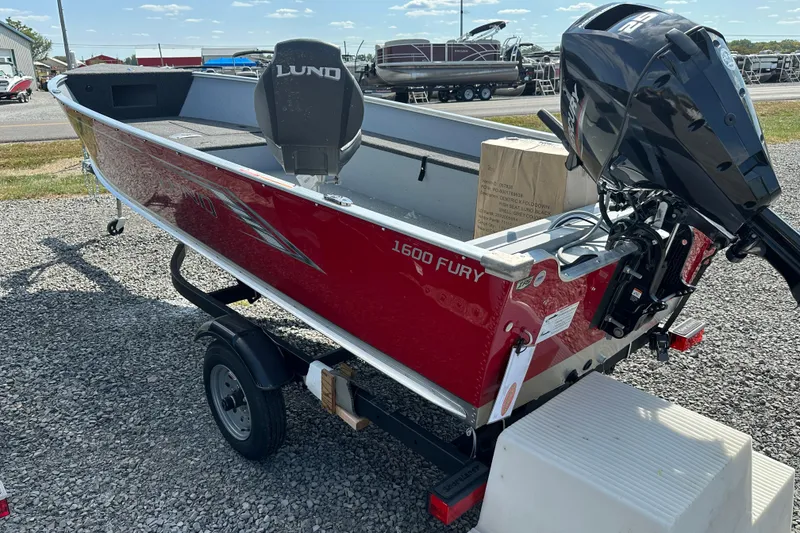 Slide: The Image of 2025 Lund 1600 Fury Tiller boat, red exterior, on trailer, outdoor display. - 3