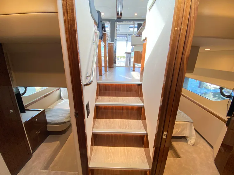 Slide: The Image of Interior of 2025 Riviera 465 SUV yacht, featuring luxurious cabins and wooden staircase. - 17