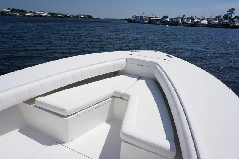 Slide: The Image of 2012 Regulator 32 Forward Seating boat with white cushioned seats on calm water. - 41