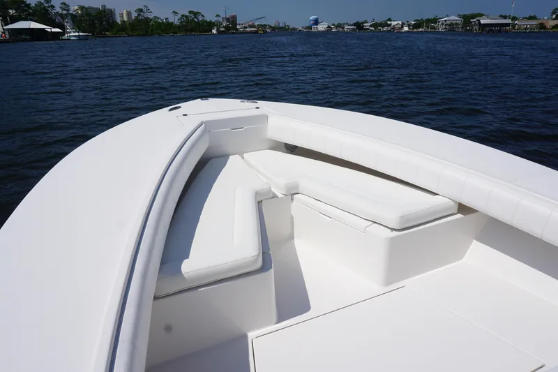 Slide: The Image of 2012 Regulator 32 Forward Seating boat with white cushioned seats on calm water. - 42